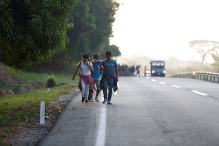 Central American migrants eat mangoes for breakfast as they walk during their journey towards the United States, in Mapastepec, Mexico April 20, 2019. REUTERS/Jose Cabezas
