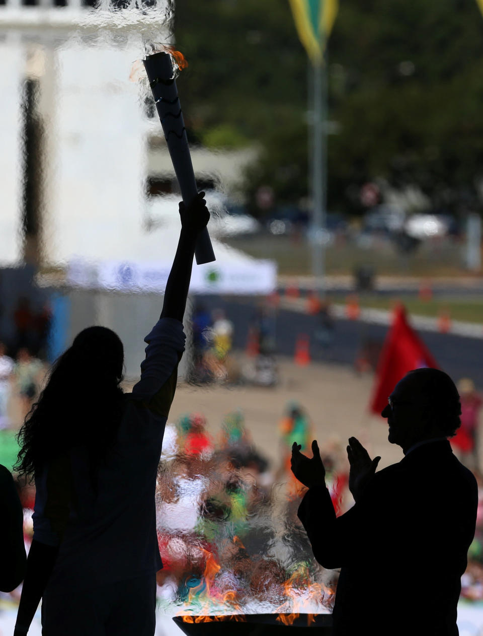 Olympic torch bearer Fabiana Claudino (L), captain of the Brazilian volleyball team, holds the flame next to Carlos Nuzman, president of the Rio 2016 Organizing Committee, during the Olympic Flame torch relay at Planalto Palace in Brasilia, Brazil, May 3, 2016. REUTERS/Adriano Machado