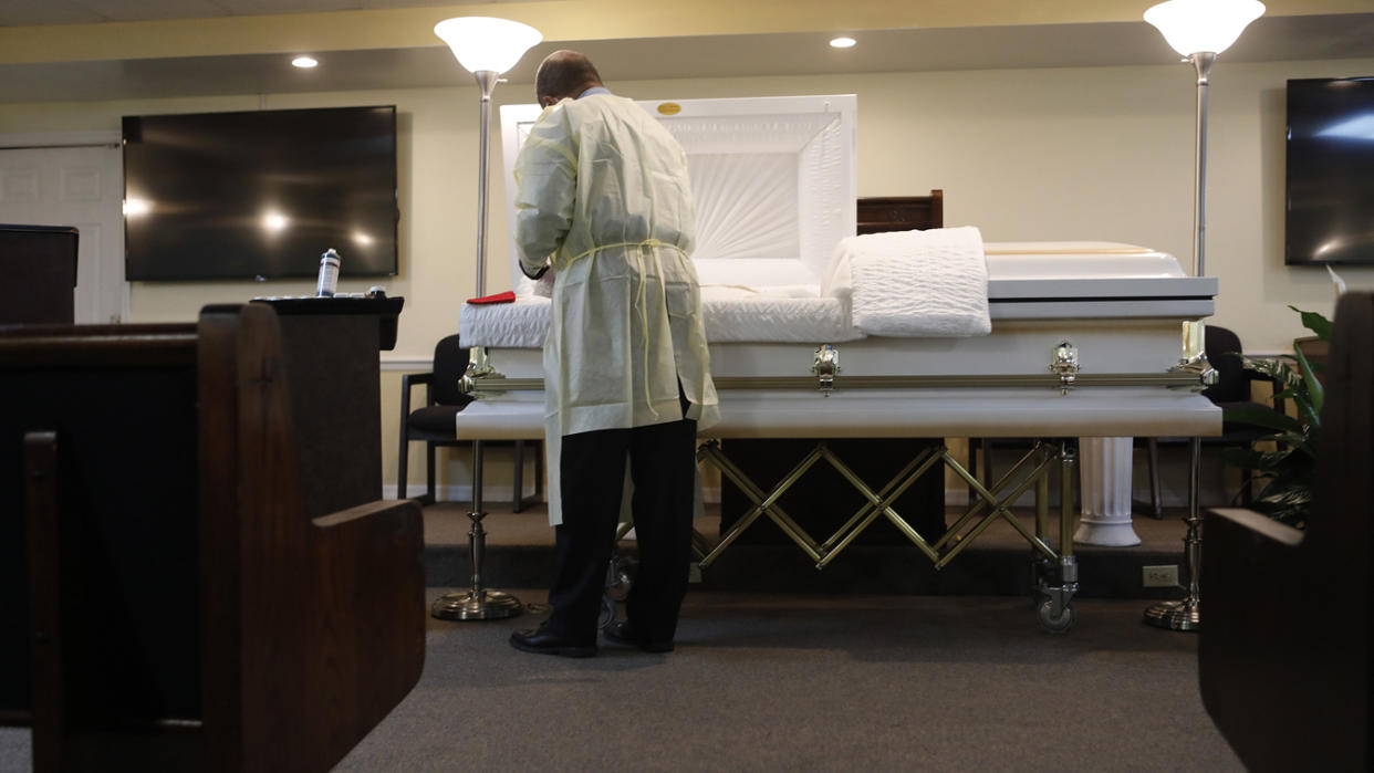 An undertaker in Tampa, Fla., tends to a man who died of COVID-19. (Octavio Jones/Getty Images)