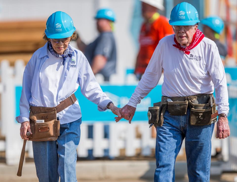 Former President Jimmy Carter holds hands with his wife and former First Lady Rosalynn Carter while working with other volunteers on site during the first day of the weeklong Jimmy & Rosalynn Carter Work Project on Monday, Aug. 27, 2018, in Mishawaka.