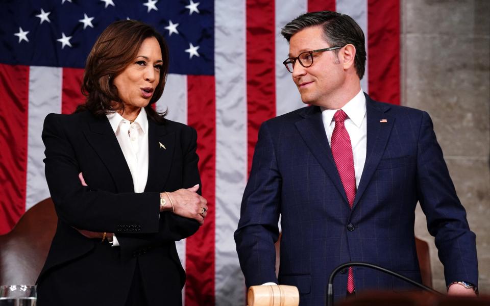 Speaker of the House Mike Johnson (R) chats with US Vice President Kamala Harris (L) in the House of Representatives