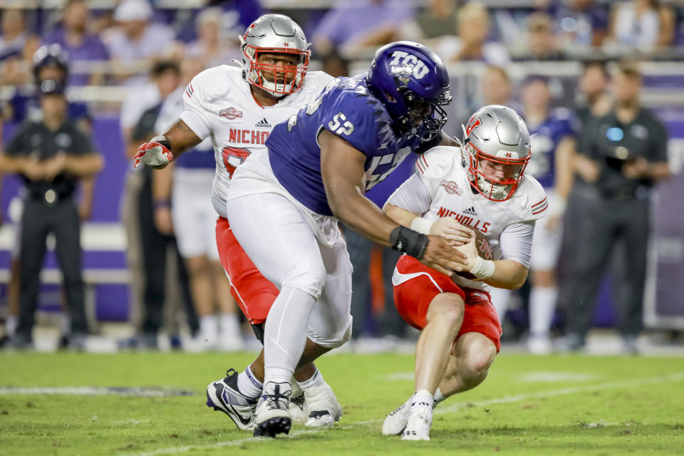 Nicholls State quarterback Pat McQuaide, right, is sacked by TCU defensive lineman Damonic Williams (52) during the first half of an NCAA college football game, Saturday, Sept. 9, 2023, in Fort Worth, Texas. (AP Photo/Gareth Patterson)