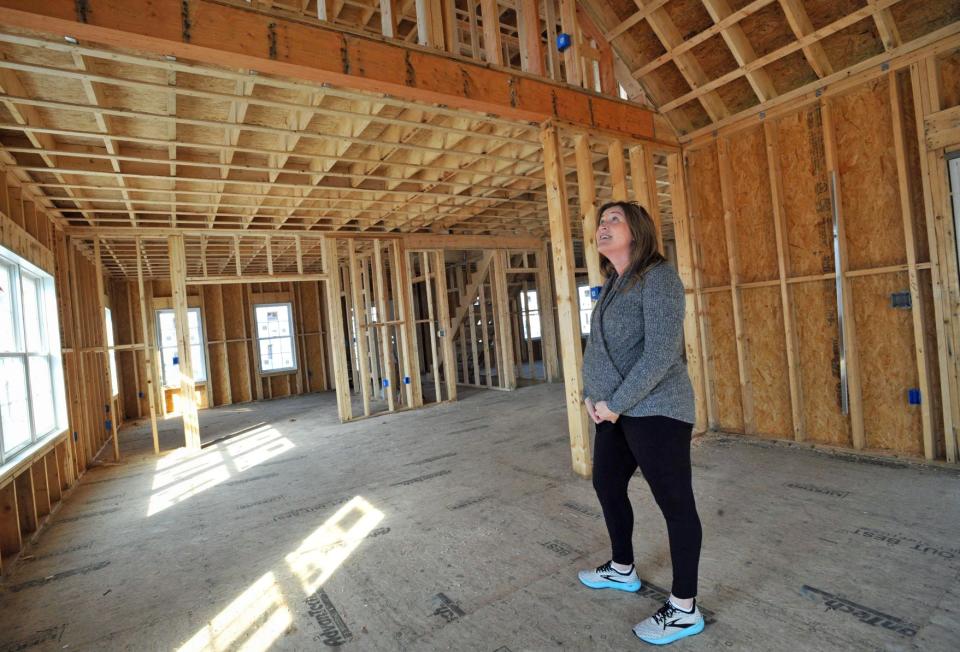 Kate Johnson, of Boston, checks out one of the large rooms in a home under construction in the Curtis Estates in Scituate during an open house Saturday, Feb. 12, 2022.