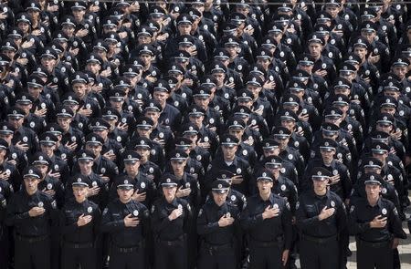 Police officers sing the national anthem during an oath-taking ceremony, which started up the work of a new police patrol service, part of the Interior Ministry reform initiated by Ukrainian authorities, in Kiev, Ukraine, July 4, 2015. REUTERS/Markiv Mykhailo/Ukrainian Presidential Press Service/Pool