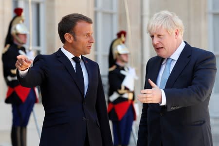 French President Emmanuel Macron welcomes British Prime Minister Boris Johnson before a meeting on Brexit at the Elysee Palace in Paris