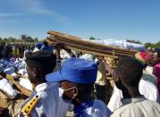 Men carry the bodies of people killed by militant attack, during a mass burial in Zabarmari