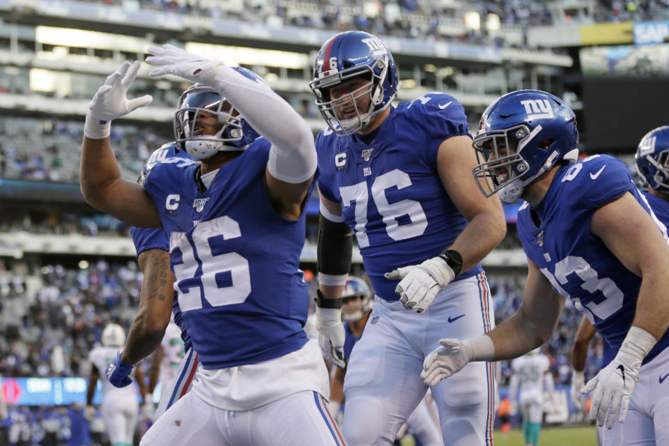 New York Giants running back Saquon Barkley (26) celebrates with teammates after scoring a touchdown in the second half of an NFL football game against the Miami Dolphins, Sunday, Dec. 15, 2019, in East Rutherford, N.J. (AP Photo/Adam Hunger)