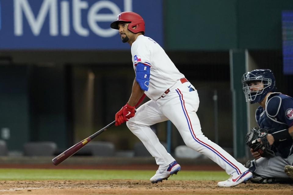 Texas Rangers' Marcus Semien (2) and Minnesota Twins' Gary Sanchez, right, watch Semien's RBI triple during the eighth inning of a baseball game Saturday, July 9, 2022, in Arlington, Texas. (AP Photo/Tony Gutierrez)