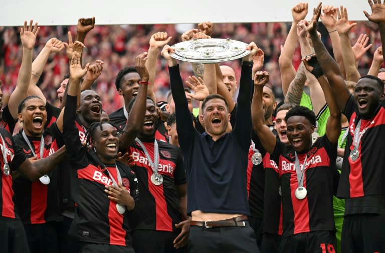 Champions: <a class="link " href="https://sports.yahoo.com/soccer/teams/leverkusen/" data-i13n="sec:content-canvas;subsec:anchor_text;elm:context_link" data-ylk="slk:Bayer Leverkusen;sec:content-canvas;subsec:anchor_text;elm:context_link;itc:0">Bayer Leverkusen</a> coach Xabi Alonso and his players celebrate with the Bundesliga trophy (INA FASSBENDER)
