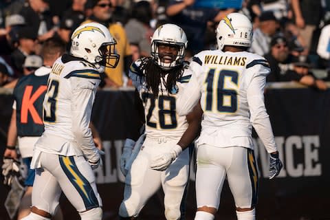 Los Angeles Chargers running back Melvin Gordon (28) is congratulated by wide receiver Keenan Allen (13) and wide receiver Tyrell Williams (16) for scoring a touchdown against the Oakland Raiders during the third quarter at Oakland Coliseum - Credit: Kyle Terada/USA Today