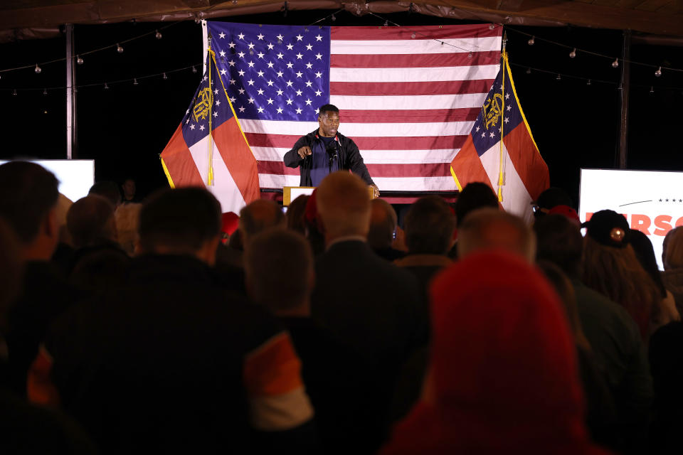 U.S. Senate candidate Herschel Walker onstage with an American flag in the background at a campaign rally in Cumming, Ga.