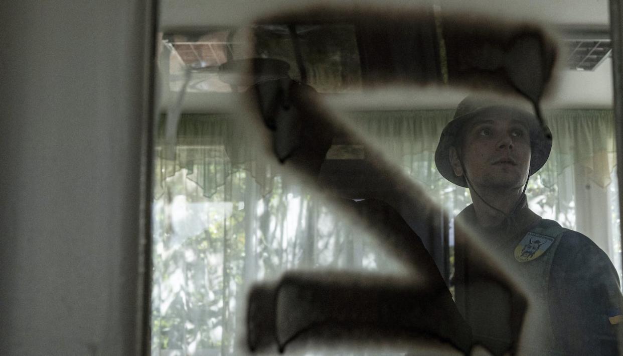 A Ukrainian serviceman inspects a classroom with a sign 'Z' on the door used by Russian forces in the retaken area of Kapitolivka, Ukraine, Sept. 25, 2022. Russian President Vladimir Putin spread an outlandish conspiracy theory to justify military invasion of Ukraine. (AP Photo/Evgeniy Maloletka)