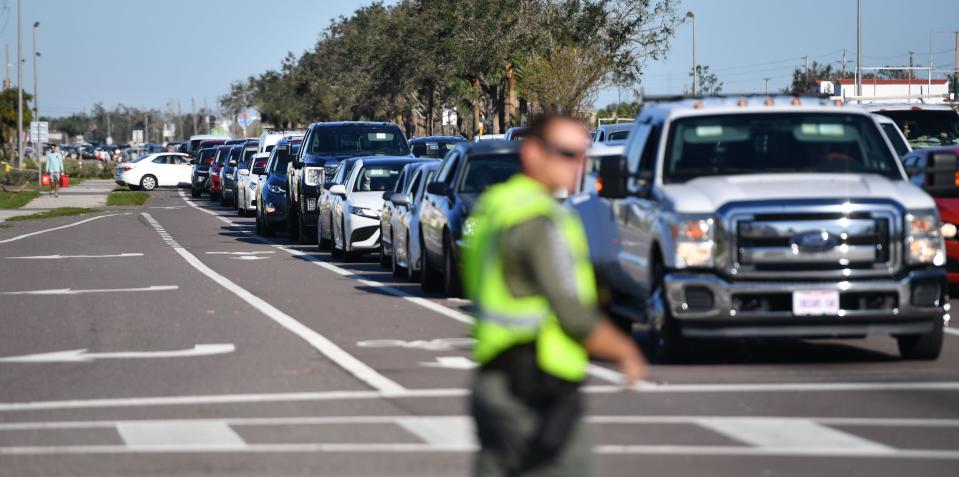 A Charlotte County Sheriff's deputy directs traffic at U.S. 41 and Midway Blvd. in Port Charlotte, Florida, following Hurricane Ian on Friday, Sept. 30, 2022. The line of cars waiting to buy gas at Wawa stretched more than a mile along U.S. 41.  Drivers near the front of the line said they had been waiting three hours to buy gas.