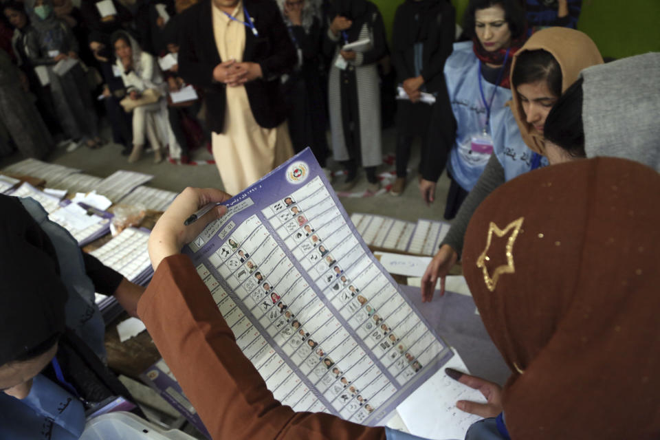 Afghan election workers count ballots during the parliamentary elections, at a polling station in Kabul, Afghanistan, Sunday, Oct. 21, 2018. The elections entered a second day after delays caused by violence and technical issues, as a roadside bomb killed nearly a dozen civilians on Sunday, including several children. (AP Photo/Rahmat Gul)