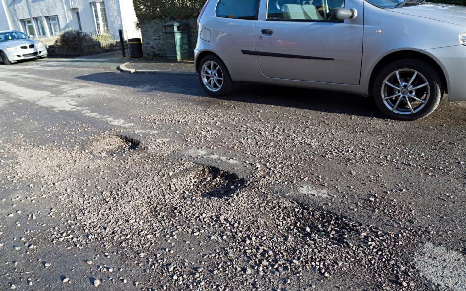 Damage to a road after heavy rain - Chris Howe/Alamy Stock Photo