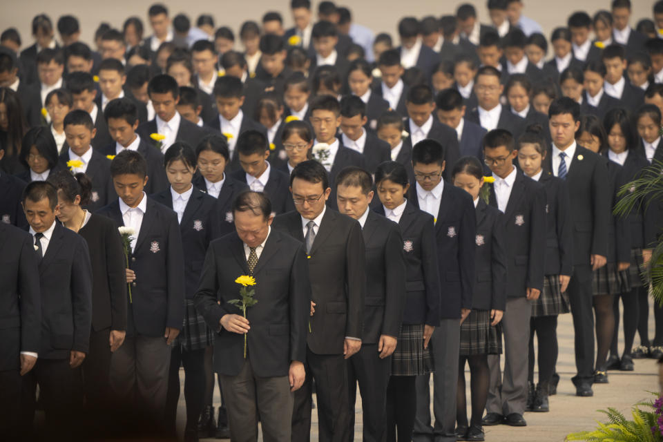 Participants bow their heads during a ceremony to mark Martyr's Day at the Monument to the People's Heroes at Tiananmen Square in Beijing, Friday, Sept. 30, 2022. (AP Photo/Mark Schiefelbein)