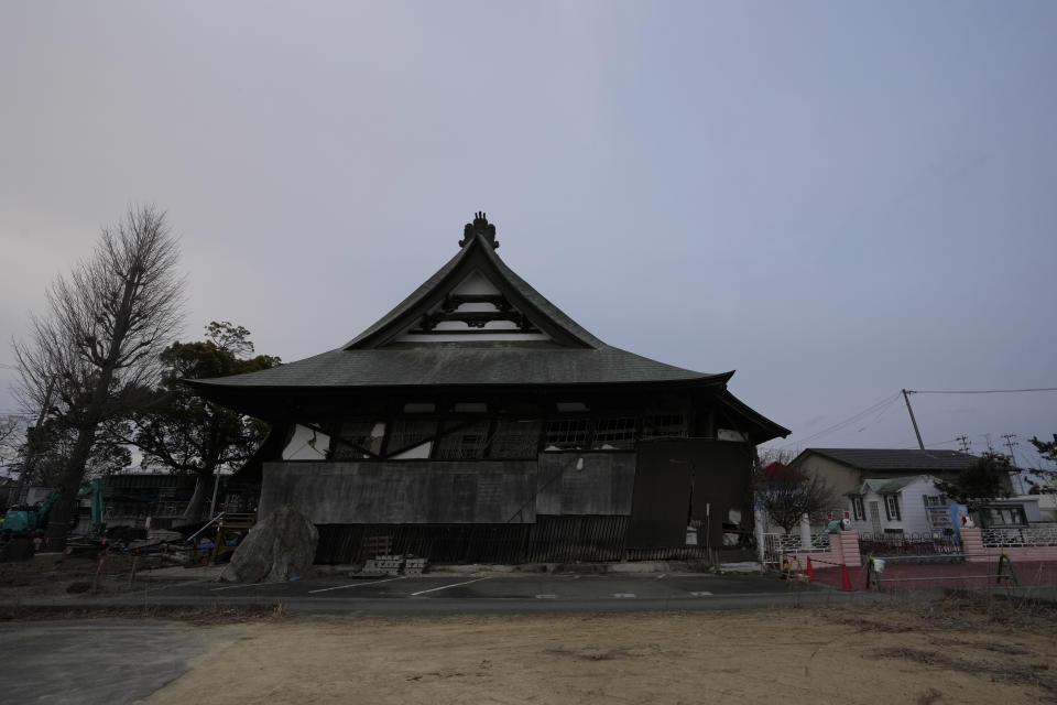 A damaged Buddhist temple and a kindergarten are left abandoned in Futaba, northeastern Japan, Tuesday, March 1, 2022. Until recently, Futaba, home to the Fukushima Daiichi nuclear plant, has been entirely empty of residents since the March 2011 disaster. (AP Photo/Hiro Komae)