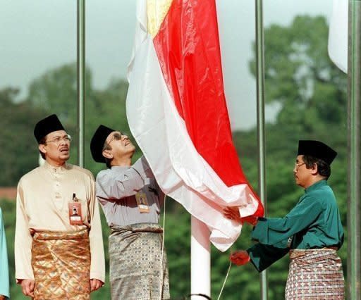 Former Malaysian prime minister Mahathir Mohamad (C) and Anwar Ibrahim (L) in 1998. In the 1990s, Anwar was groomed by Mahathir to take power one day until a bitter row between them saw Anwar ousted in 1998, beaten, and ultimately jailed on sodomy and graft charges