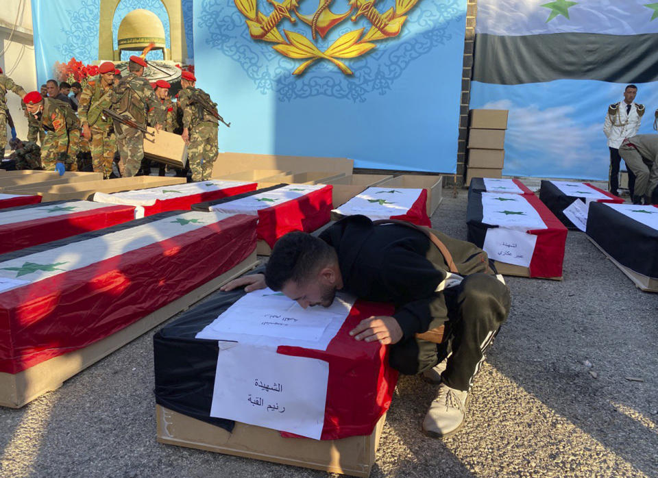 Syrian Lt. Ibrahim Shaaban kisses the coffin of his fiancee Raneem Quba, 23, who was killed along with her father Mohammed and younger sister Rima while attending the graduation of her brother Lt. Hussein Quba during a mass funeral procession in Homs, Syria, Friday, Oct. 6, 2023. Family members of some of the victims of deadly drone attacks on a crowded military graduation that killed scores gathered outside a military hospital in this central city Friday to collect the bodies of their loved ones who lost their lives in one of Syria's deadliest single attacks in years. (AP Photo/Albert Aji)