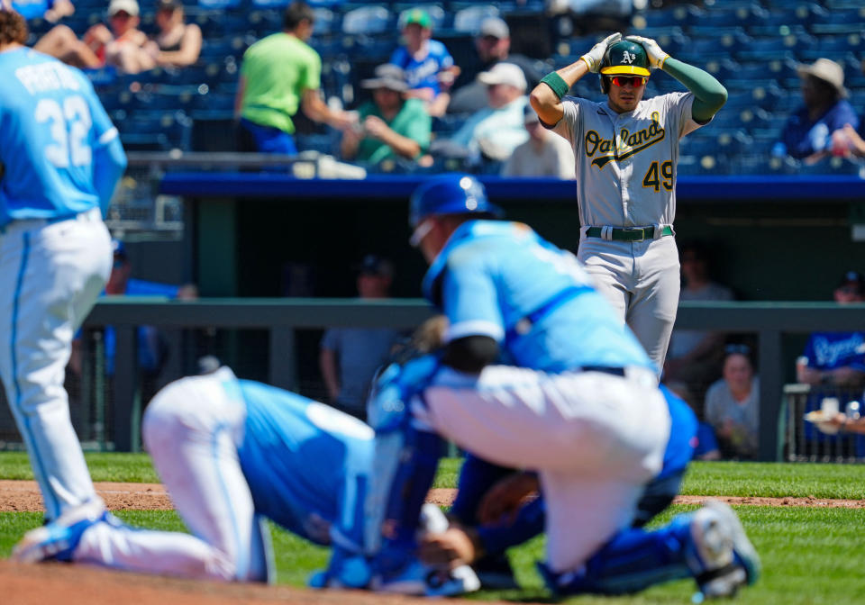 Ryan Noda, background, reacts after his line drive hit Royals pitcher Ryan Yarbrough in the face. (Jay Biggerstaff/Reuters)