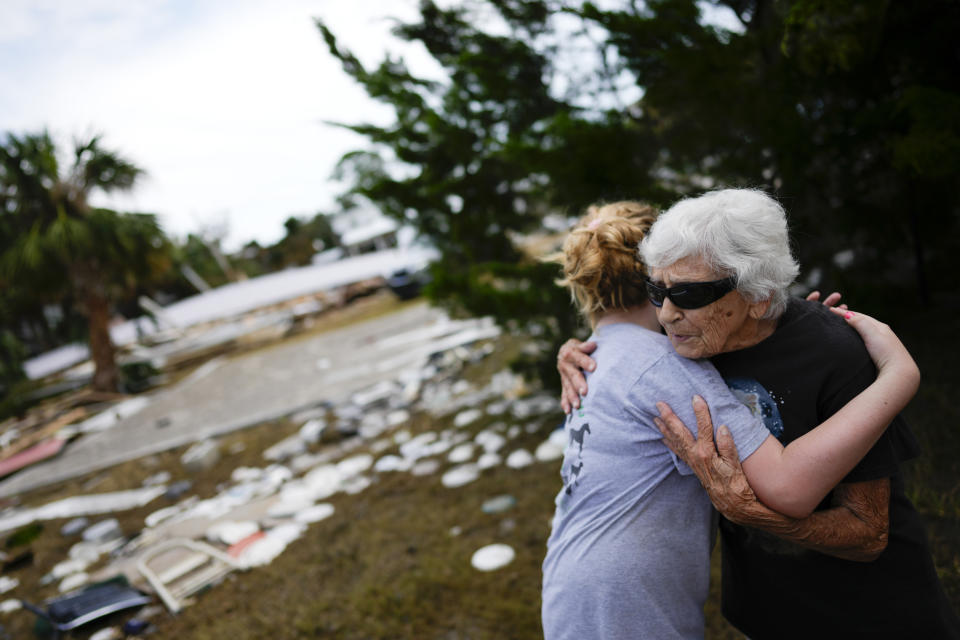 Tina Brotherton, de 88 años, recibe un abrazo de su vecina de 9 años de edad, Lainey Hamelink, el viernes 1 de septiembre de 2023, luego de volver al sitio donde se encontraba su negocio, el cual fue arrasado por huracán Idalia, en Horseshoe Beach, Florida. (AP Foto/Rebecca Blackwell)
