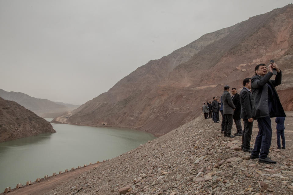 This image provided by World Press Photo is part of a series titled Battered Waters which won the World Press Photo Long Term Projects award by photographer Anush Babajanyan, VII Photo for National Geographic Society, shows visitors photographing the Rogun Dam, being built in eastern Tajikistan to provide hydroelectric power, on 22 March 2022. The 335-meter-high dam is due for completion in 2028-2029. (Anush Babajanyan, VII Photo for National Geographic Society/World Press Photo via AP)