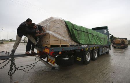 Palestinians cover cartons containing vegetables before exporting them to Israel, at the Kerem Shalom crossing in Rafah in the southern Gaza Strip March 12, 2015. REUTERS/Ibraheem Abu Mustafa