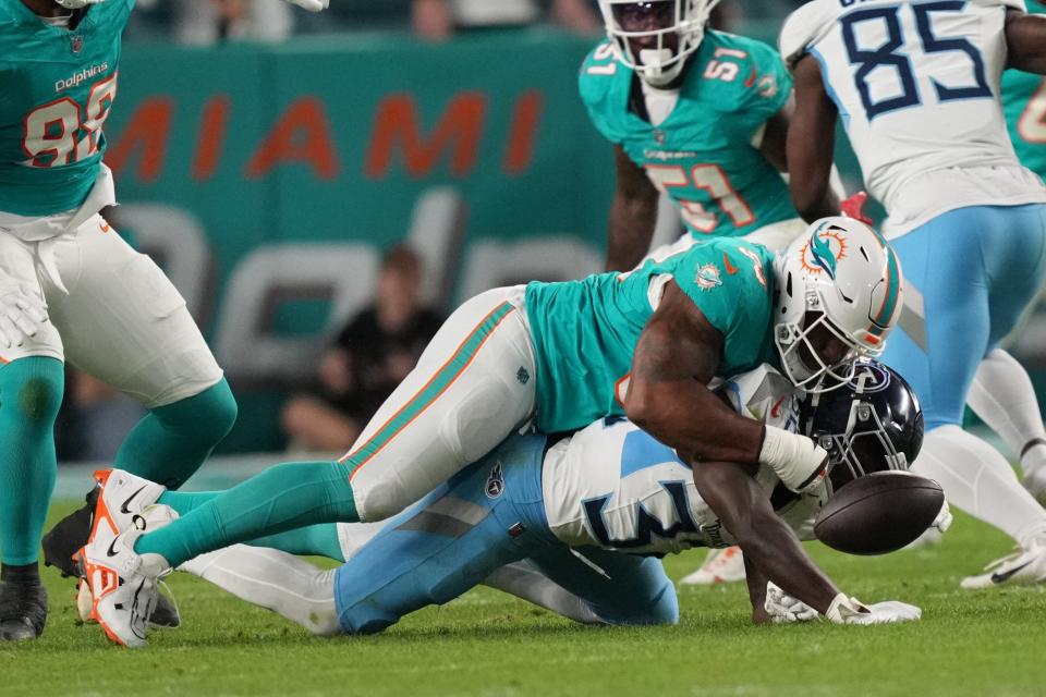 Miami Dolphins defensive tackle Da'Shawn Hand (93) forces a fumble by Tennessee Titans running back Tyjae Spears (32) during the first half of an NFL game at Hard Rock Stadium in Miami Gardens, Dec. 11, 2023.