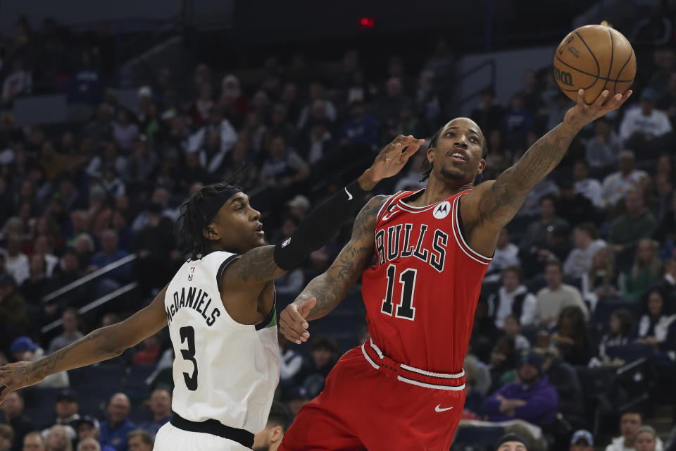 Chicago Bulls forward DeMar DeRozan (11) goes up to the basket against Minnesota Timberwolves forward Jaden McDaniels (3) during the first half of an NBA basketball game Sunday, Dec. 18, 2022, in Minneapolis. (AP Photo/Stacy Bengs)