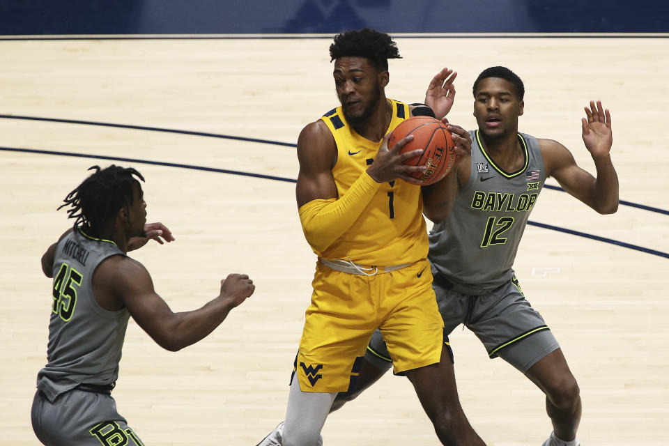 West Virginia forward Derek Culver (1) is defended by Baylor guards Davion Mitchell (45) and Jared Butler (12) during the first half of an NCAA college basketball game Tuesday, March 2, 2021, in Morgantown, W.Va. (AP Photo/Kathleen Batten)