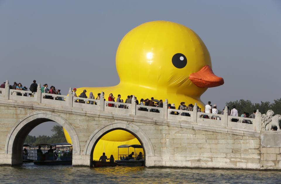 An inflated Rubber Duck by Dutch conceptual artist Florentijn Hofman floats on the Kunming Lake at the Summer Palace in Beijing September 26, 2013. The 18-metre-high (59 ft.) inflatable sculpture will be displayed at the historic tourist attraction for a month, local media reported. (REUTERS/Jason Lee)