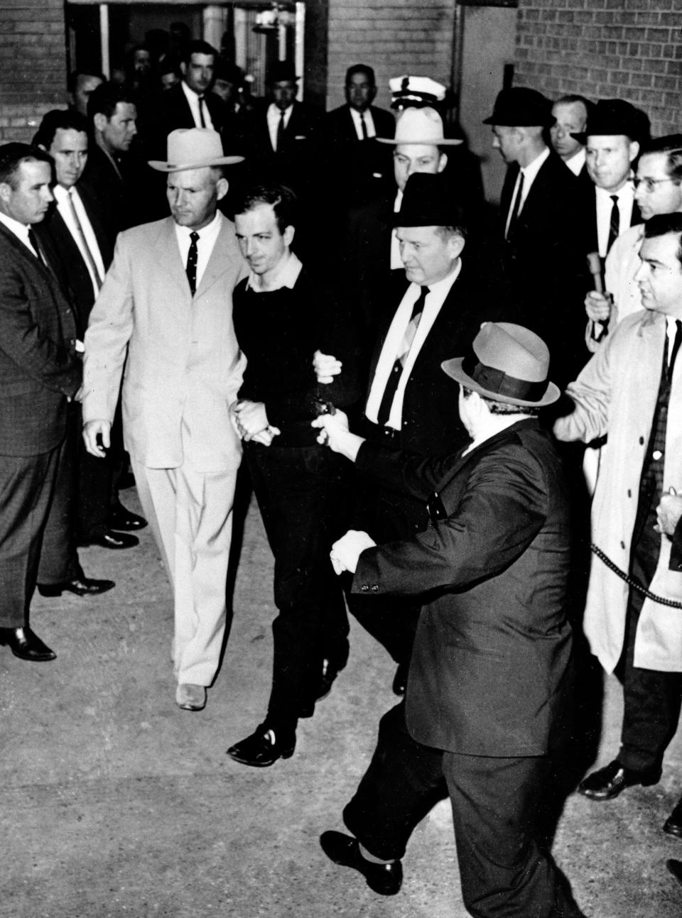 In a Nov. 24, 1963, file photo, President John F. Kennedy assassin Lee Harvey Oswald, center in handcuffs, is shot by Jack Ruby, foreground with a handgun extended in his right hand, in the underground garage of the Dallas police headquarters.