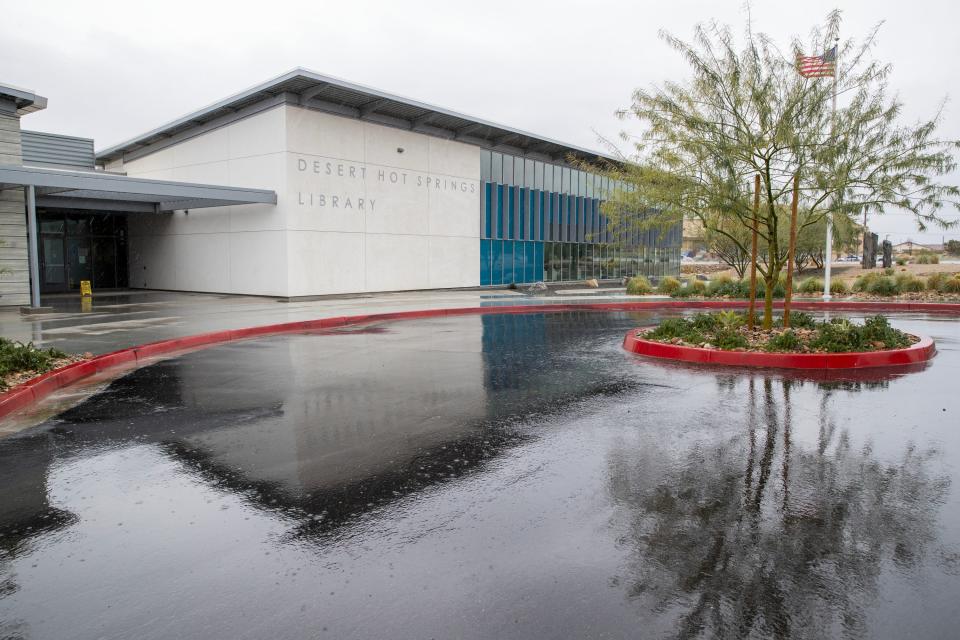 The Desert Hot Springs Library building reflects on the wet road as rain falls in Desert Hot Springs on Thursday.