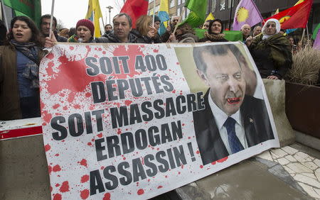 Kurdish people display a picture of Turkish President Tayyip Erdogan during a protest outside an EU-Turkey summit as the bloc is looking to Ankara to help it curb the influx of refugees and migrants flowing into Europe, in Brussels March 7, 2016. REUTERS/Yves Herman