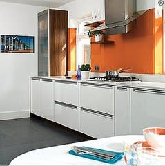 An orange backsplash stimulates the appetites of all who enter this kitchen.

Source