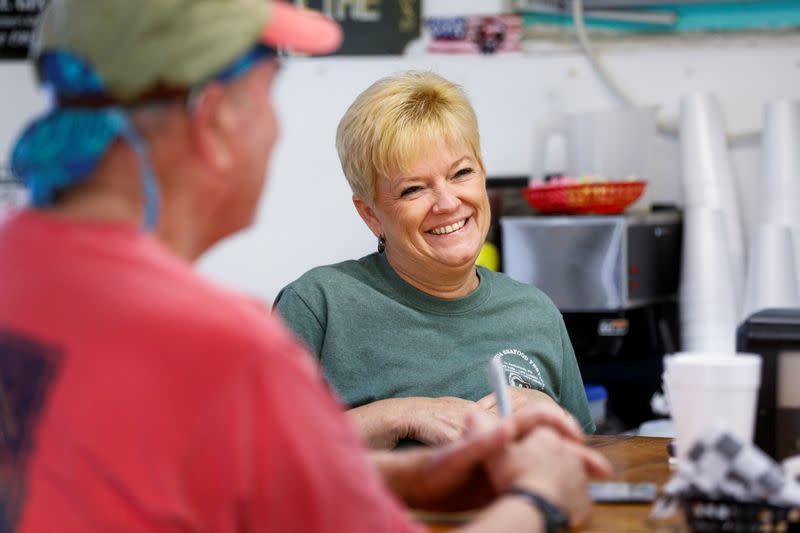 Lynn Martina, owner of Lynn's Quality Oysters in Eastpoint, Florida, U.S., talks to customers in her restaurant