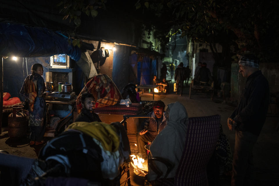 Homeless people gather around a bonfire in a street on a cold evening in New Delhi, Friday, Dec. 30, 2022. India’s 2011 census figures show about 47,000 of the city’s residents were sleeping homeless, but activists say the number is a vast underestimate and that New Delhi has more than 150,000 rough sleepers. (AP Photo/Altaf Qadri)