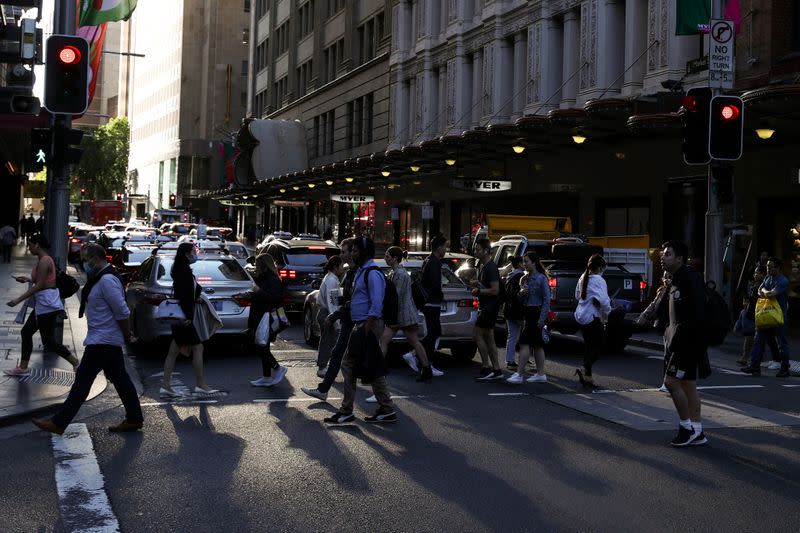 People walk through a congested intersection in the city centre of Sydney