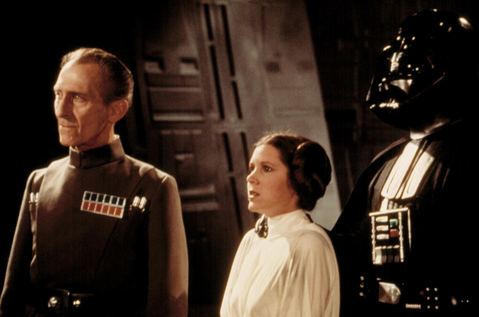 Peter Cushing as Grand Moff Tarkin and Carrie Fisher as Princess Leia in <i>Star Wars</i> (1977). Fisher’s brother, Todd, told Yahoo Entertainment that she “freaked out” when she saw they included a scene in which she uses a British accent. (Photo: Everett Collection)