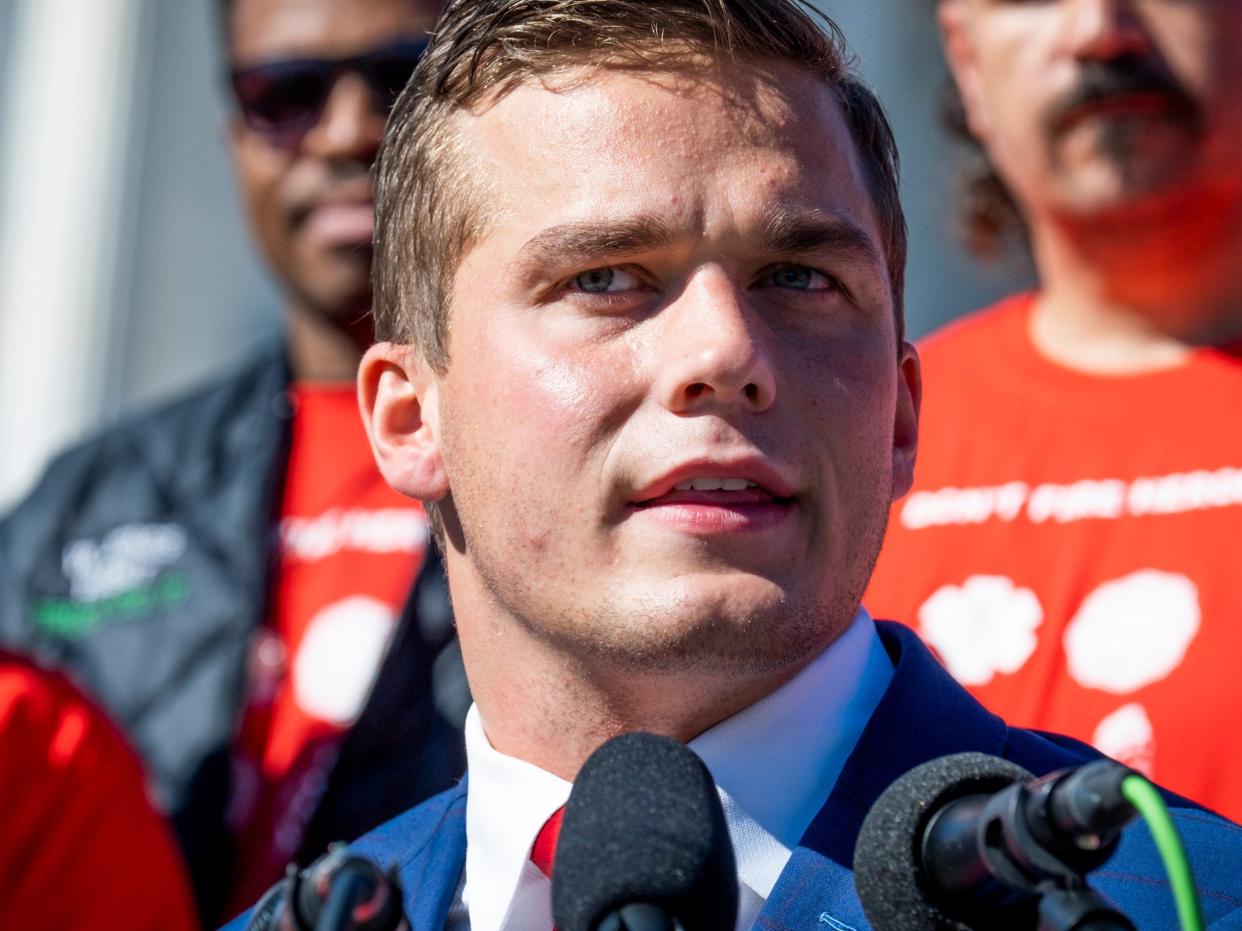 Madison Cawthorn speaks at a press conference in November with several supporters standing behind him