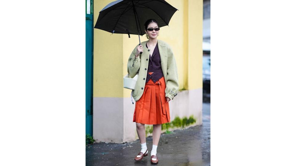 A flawless combination of knee length skirt, waistcoat, oversized jacket and loafers. 