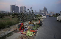 In this Thursday, Sept. 5, 2019, photo, a roadside vegetable seller waits for customers in Noida on the outskirts of New Delhi, India. Confidence in the Indian economy is giving way to uncertainty as growth in the labor-intensive manufacturing sector has come to a near standstill, braking to 0.6% in the last quarter from 12.1% in the same period a year earlier. (AP Photo/Altaf Qadri)