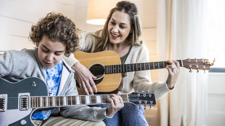 Boy and mom playing guitar