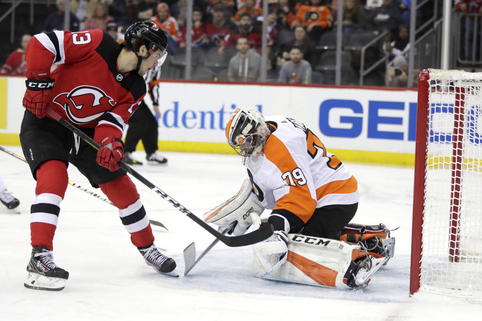 New Jersey Devils center Nico Hischier (13), of Switzerland, scores a goal on Philadelphia Flyers goaltender Carter Hart (79) during the second period of an NHL hockey game, Saturday, Jan. 12, 2019, in Newark, N.J. (AP Photo/Julio Cortez)