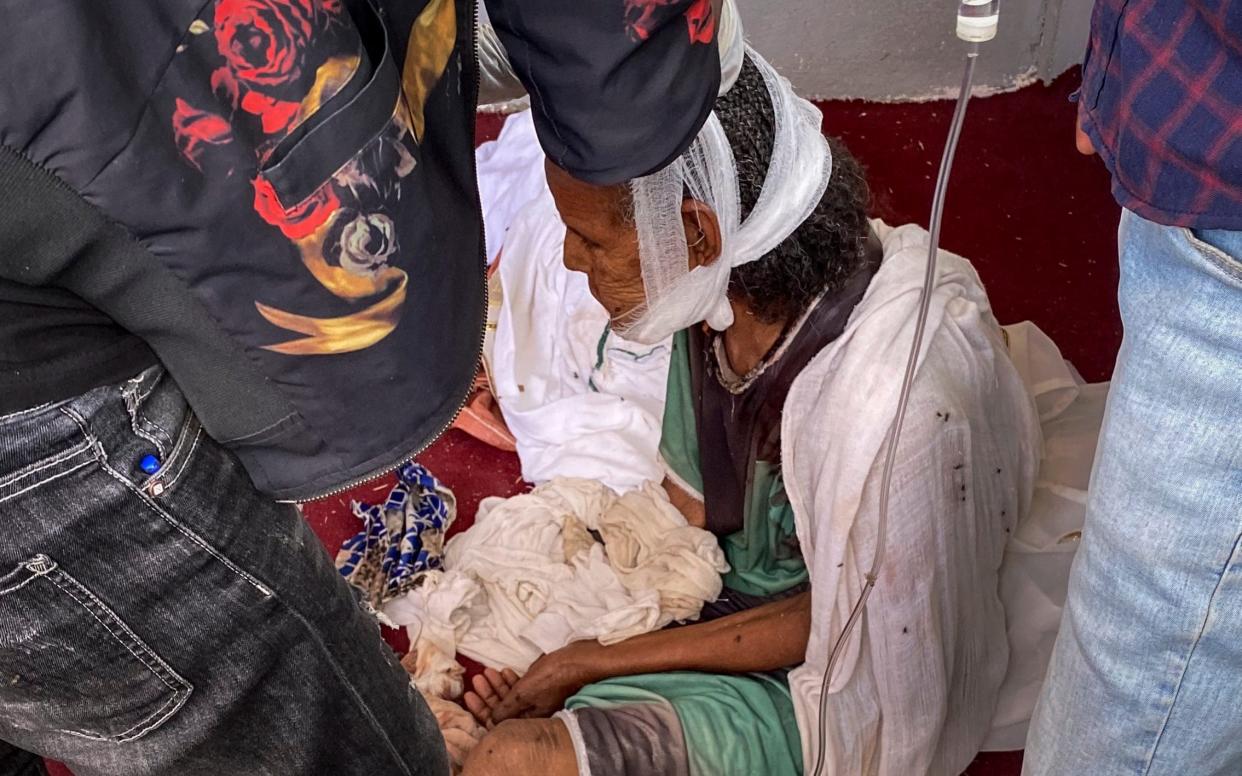 An elderly woman who fled from the town of Shire to the city of Axum to seek safety, but was then wounded in the jaw during an attack on the city - AP