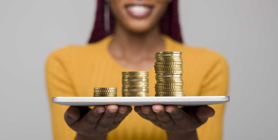 Smiling african woman with tablet in hands proposing to earn money in the Internet, panorama