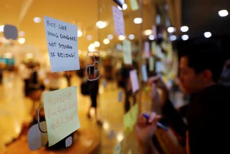 People write messages on post-it notes as they take part in a rally held by the Hong Kong Confederation of Trade Unions after a number of crew members in the aviation industry were let go for joining the anti-extradition bill protests, in Hong Kong