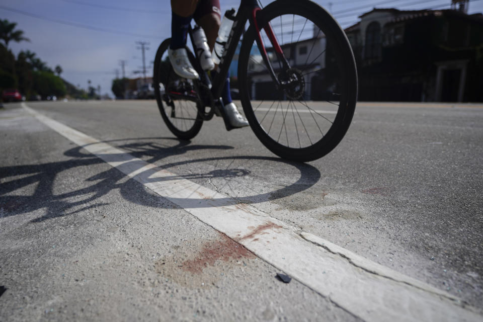 A bicyclist passes debris along the Pacific Coast Highway, Wednesday, Oct. 18, 2023, in Malibu, Calif. Tuesday. A 22-year-old driver was arrested on suspicion of manslaughter after a crash in Malibu killed four women, who are believed to be college students, and injured two others, officials said Wednesday. The six pedestrians were struck at about 8:30 p.m. Tuesday along Pacific Coast Highway about 4 miles (6.4 km) east of Pepperdine University, according to the Los Angeles County Sheriff's Department. (AP Photo/Ryan Sun)