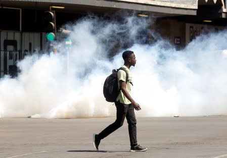 A man walks past clouds of teargas during clashes after police banned planned protests over austerity and rising living costs called by the opposition Movement for Democratic Change (MDC) party in Harare