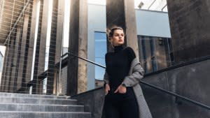 Young elegant woman in the street dressed with a grey coat